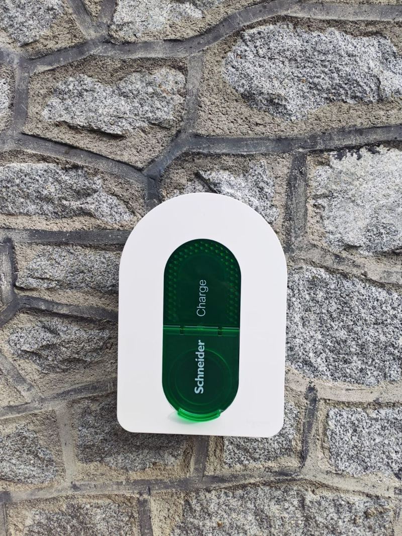 Borne de recharge pour véhicule électrique posée sur un mur en pierre par SPO Bâtiment